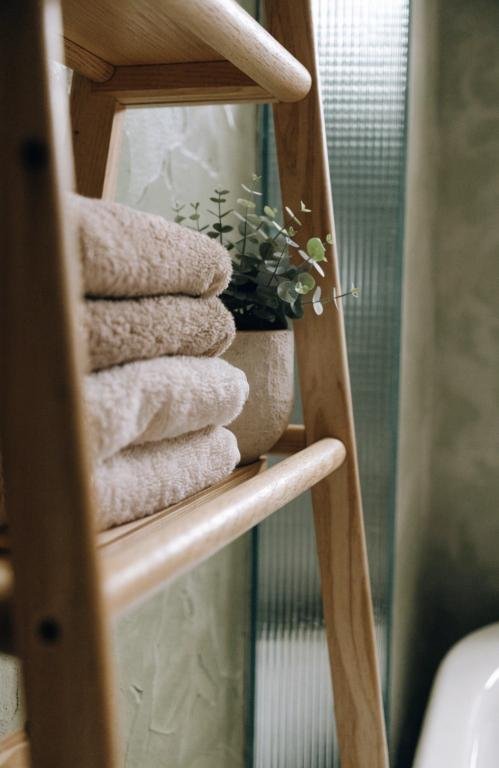 close-up-of-a-wooden-ladder-shelf-in-a-bathroom