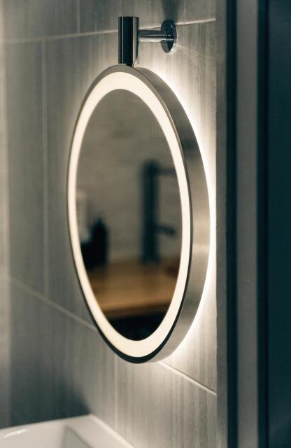 close-up-of-a-round-bathroom-mirror-with-a-glowing.