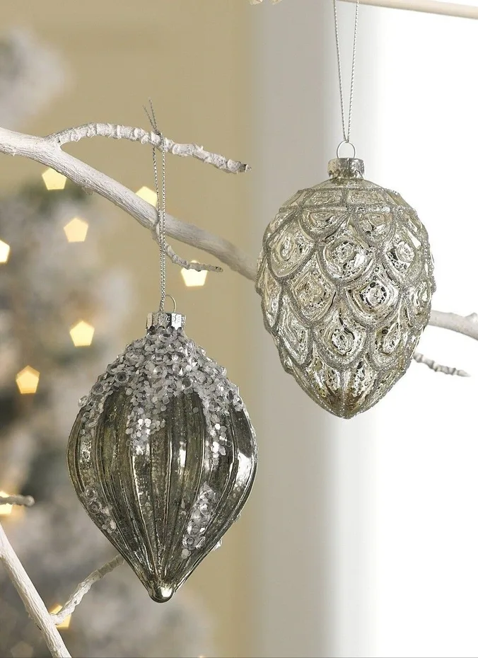 Silver mercury glass Christmas ornaments hanging on a green tree branch