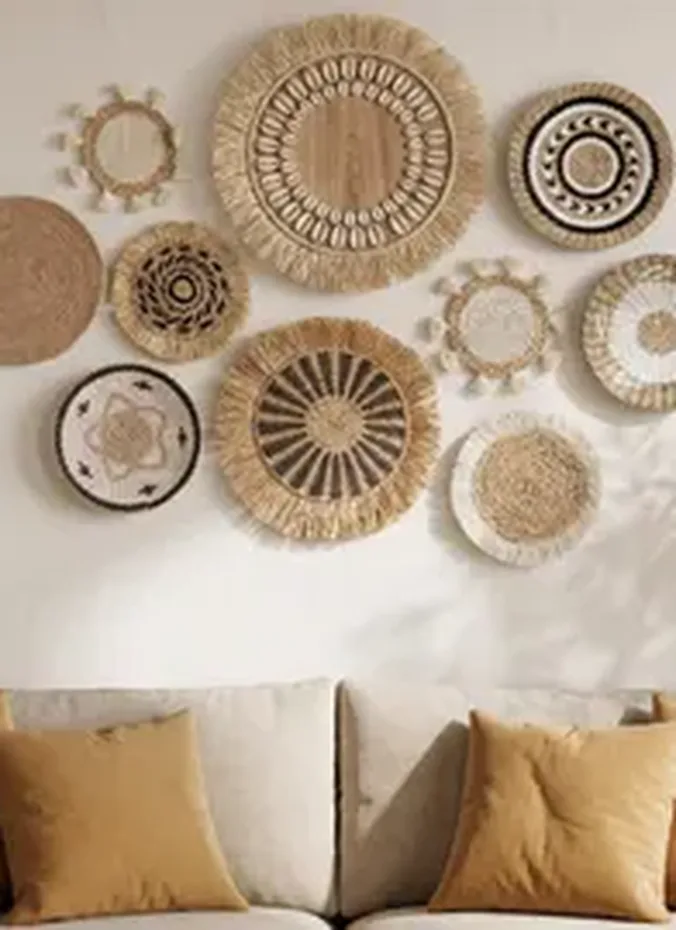 Group of flat woven baskets arranged as wall art on a dark wall