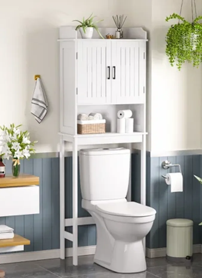 Freestanding wooden shelf straddling a toilet tank with folded towels