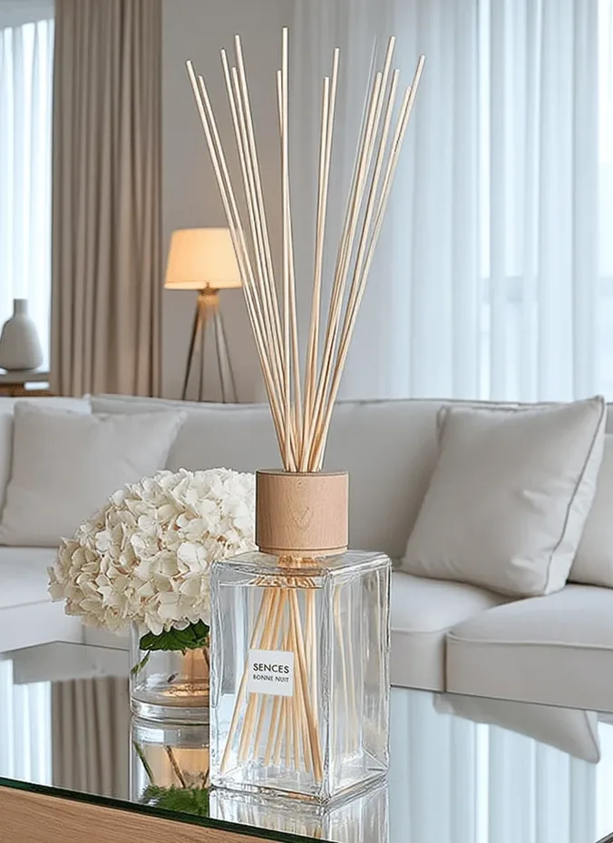 Reed fragrance diffuser in a glass bottle on a coffee table