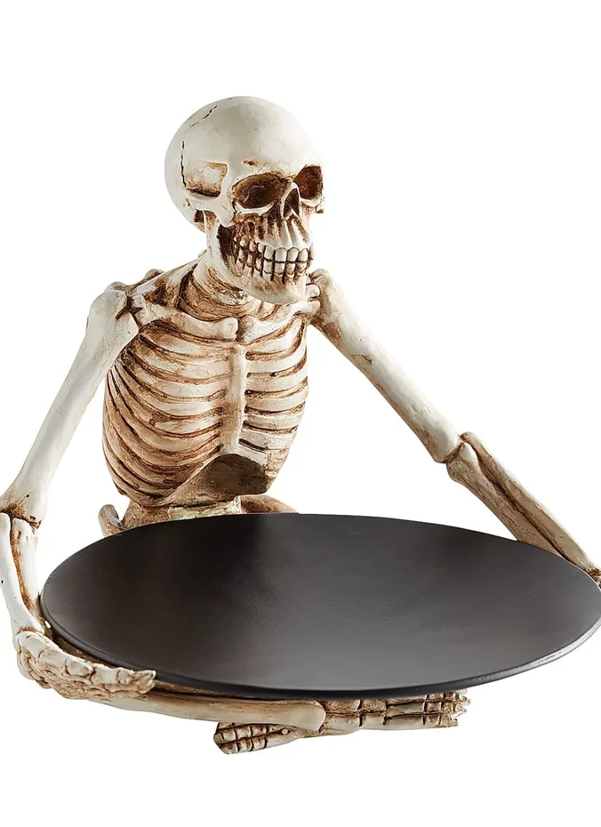 Skeleton hands rising from a tray holding candles and wrapped candy