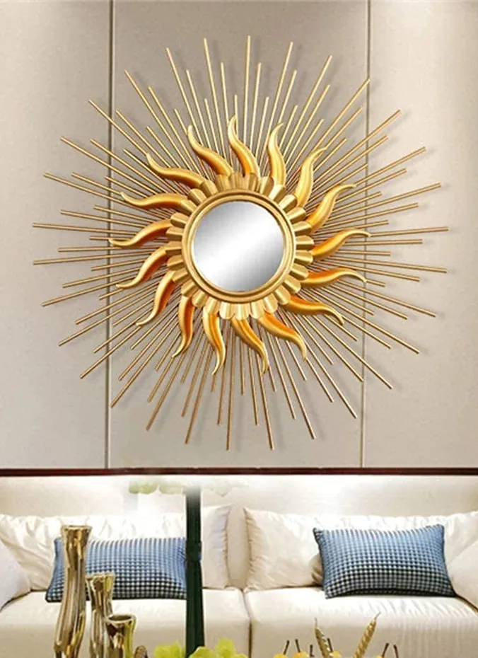 Gold sunburst mirror centered on the wall above a couch