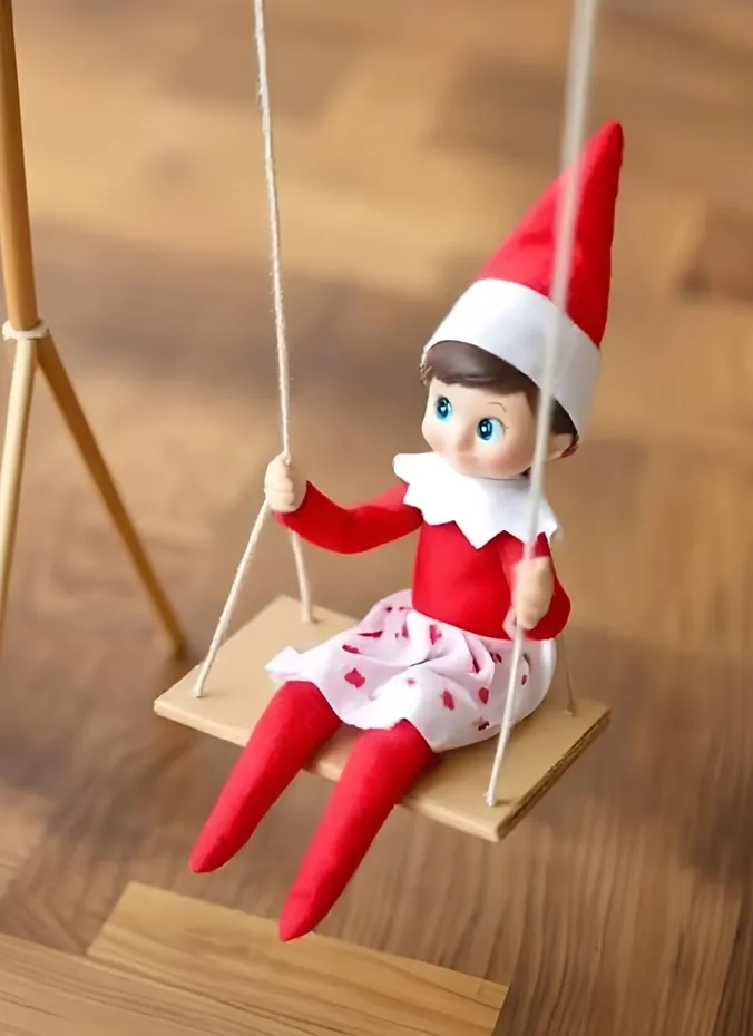 Elf on the shelf resting on a tiny handmade swing