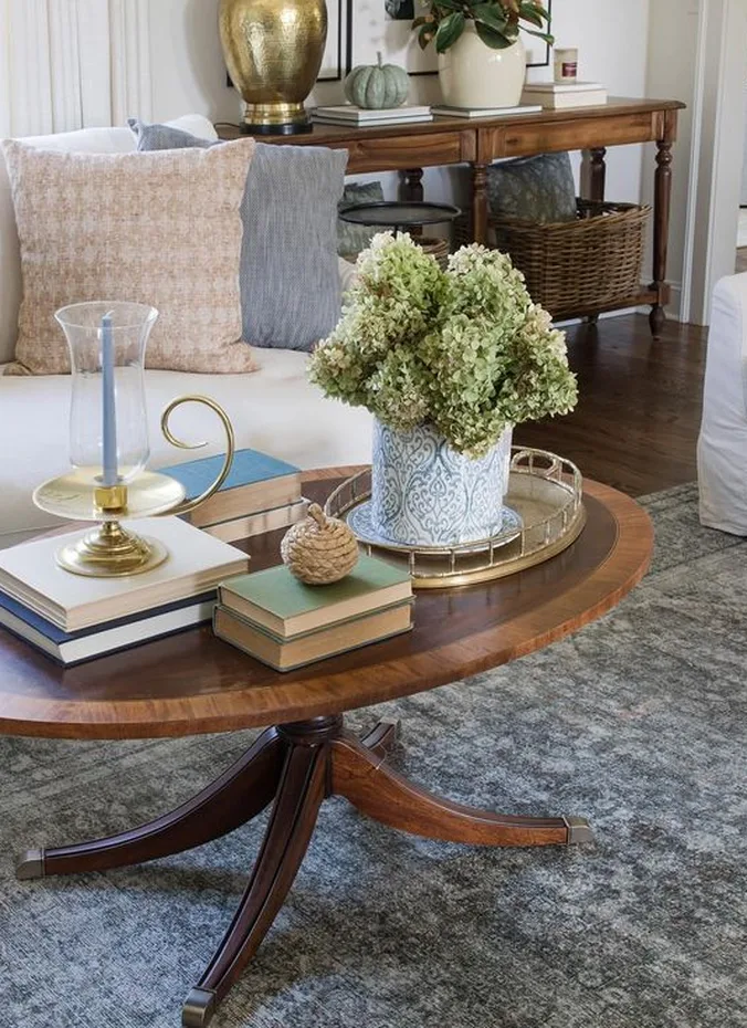 Secondhand wooden coffee table styled with books and a plant in a living room