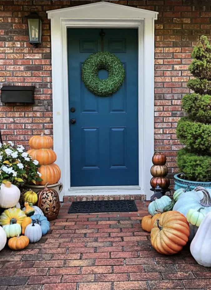 Formal topiaries styled for fall on a front porch
