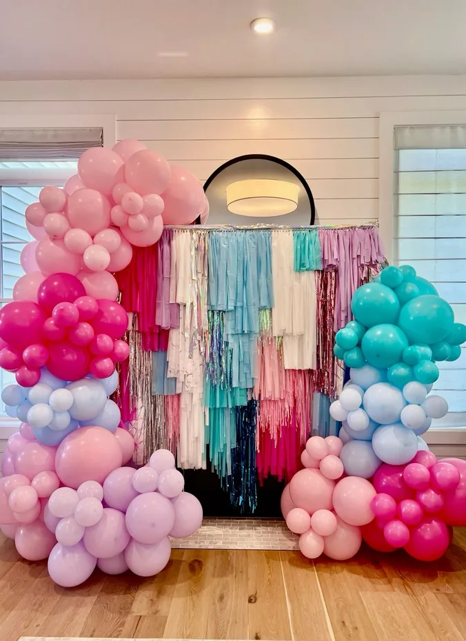 Pink and blue balloon garland decorating a party wall