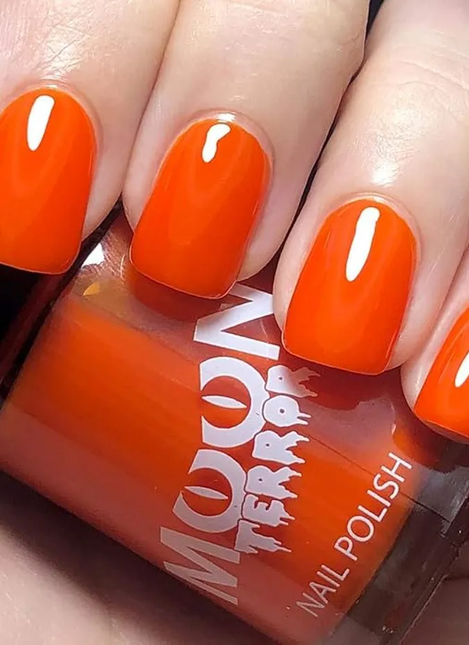 Burnt orange nail polish bottle with painted nails