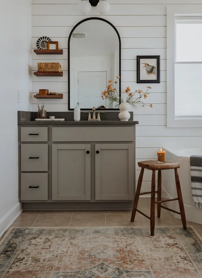 Bathroom accent wall with white shiplap panels and wood vanity