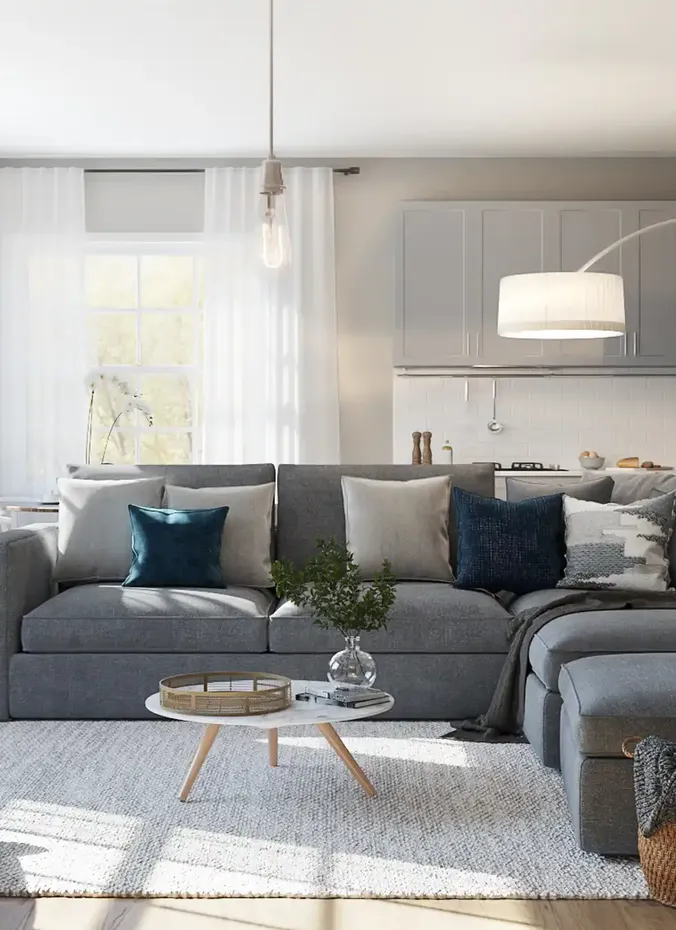 Small L shaped sofa facing an open kitchen in a compact living room