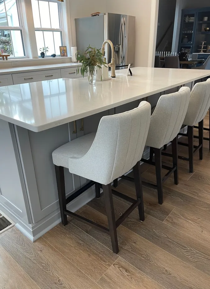 Bar stools tucked fully under a kitchen counter in a small open plan