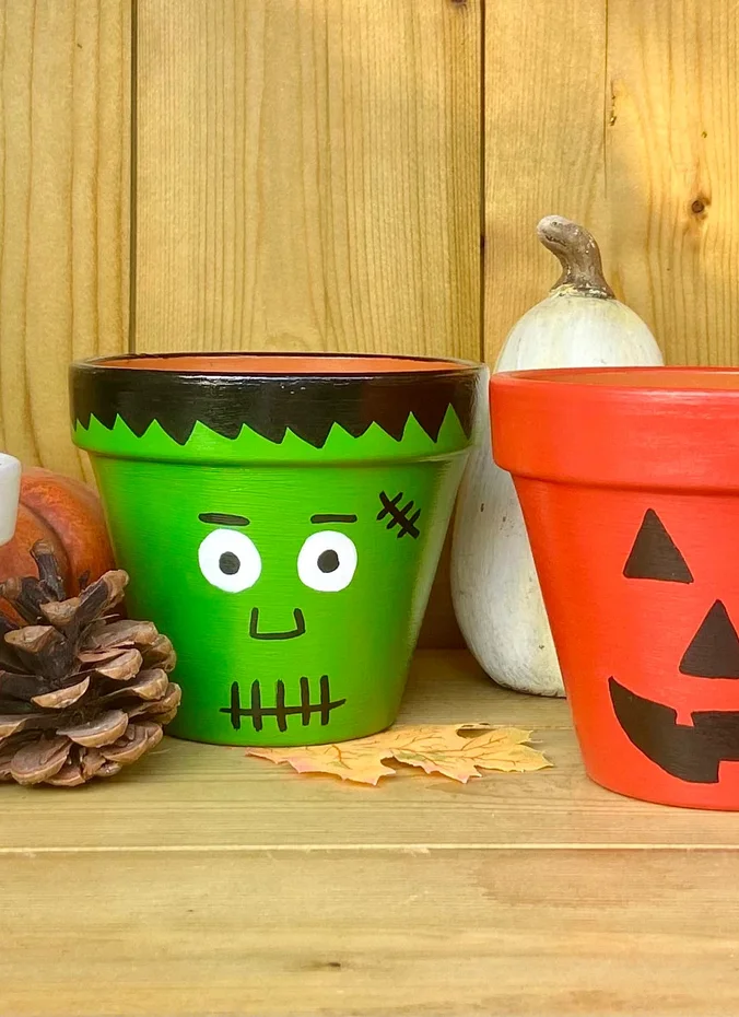 Flower pots painted for fall with spooky faces