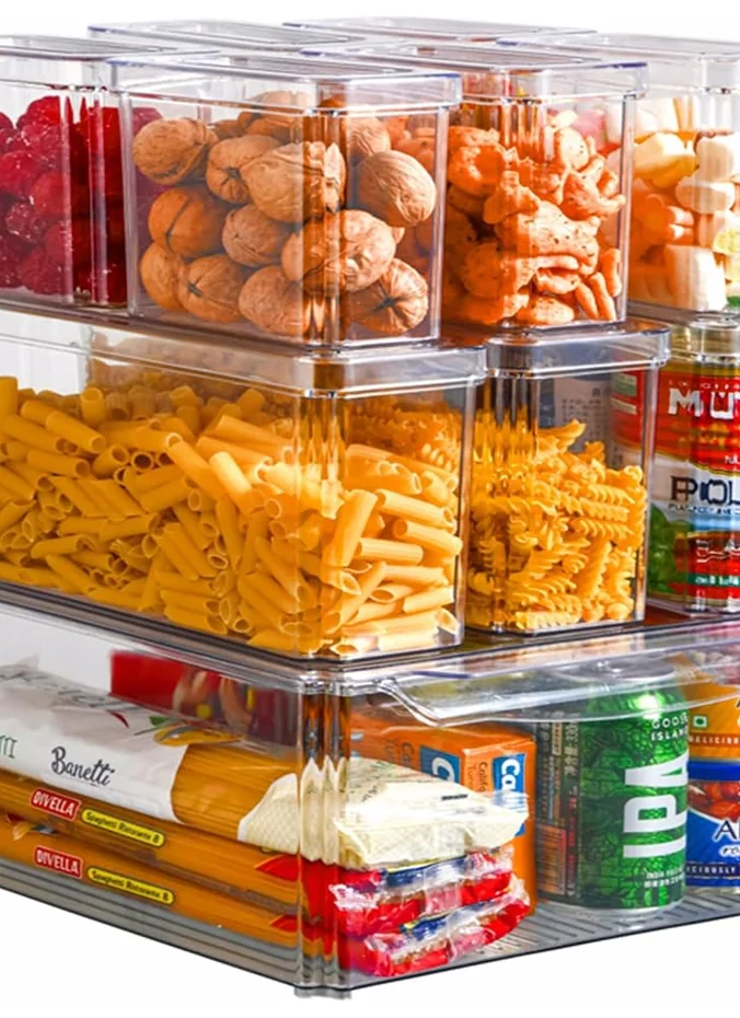 Stacked storage bins with lids organized on top of a refrigerator