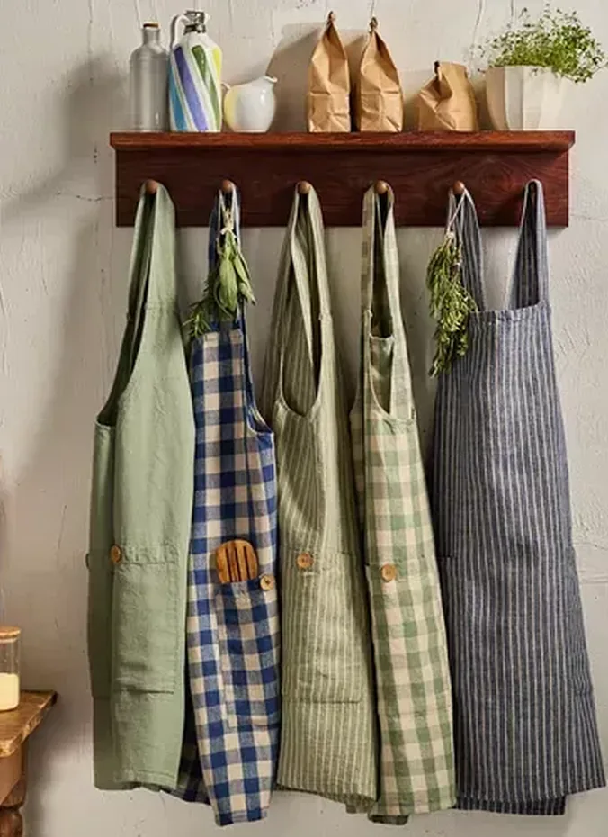 Linen aprons hanging on hooks in a kitchen