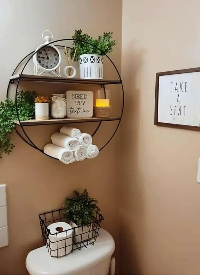 Small white clock styled on a bathroom shelf above the toilet
