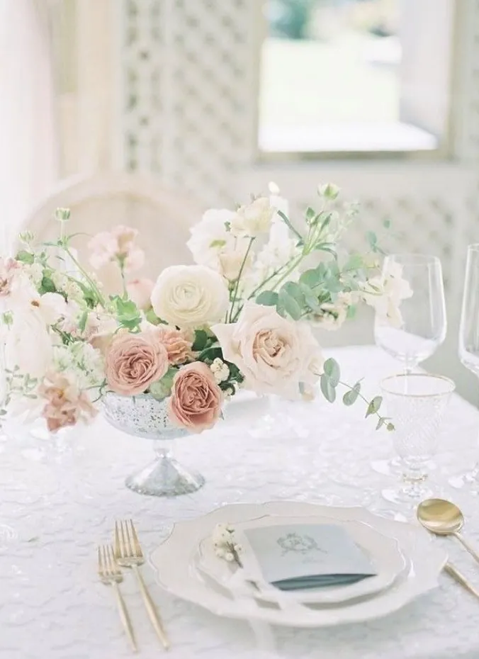 Low garden rose wedding centerpiece arrangement on a reception table