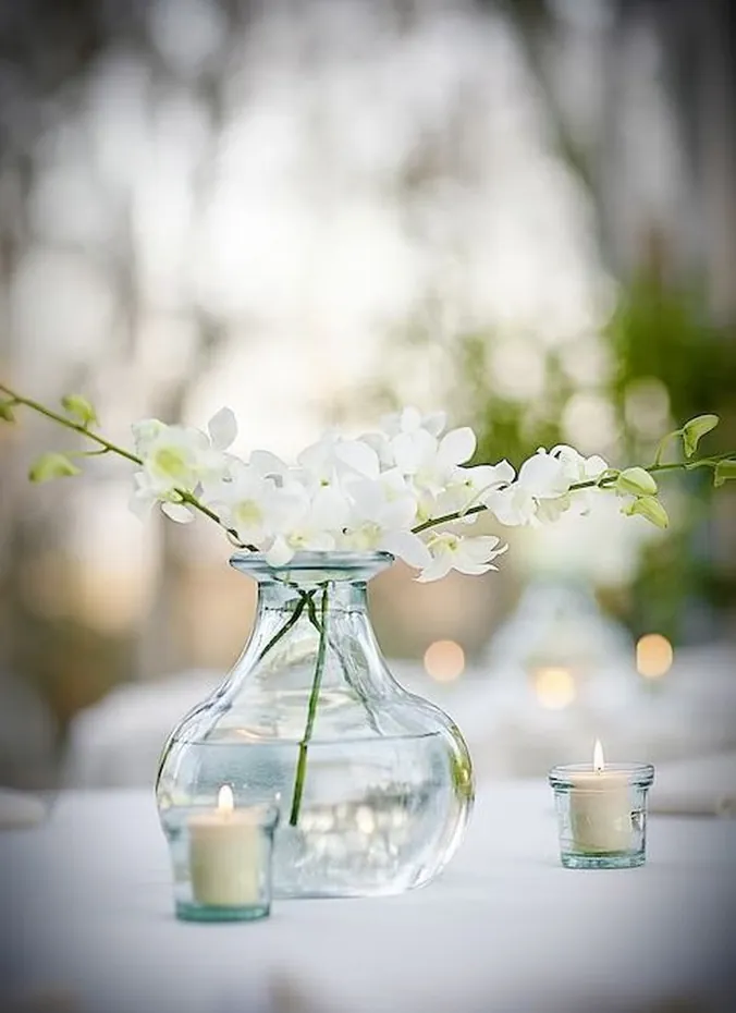 Single white orchid stem in a vase wedding centerpiece